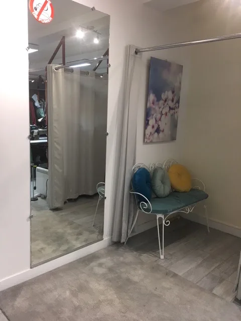Cabine d'essayage de l'atelier, avec un miroir en pied et une banquette